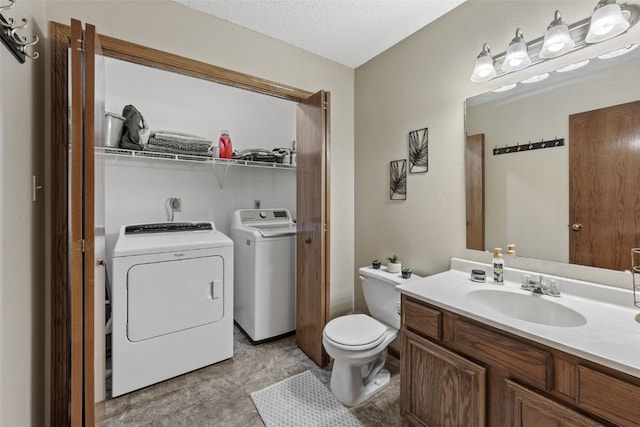 bathroom with washer and dryer, toilet, a textured ceiling, and vanity