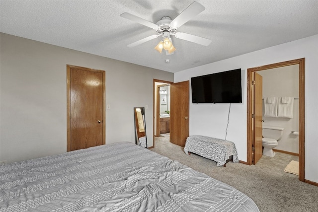 bedroom with a ceiling fan, ensuite bathroom, baseboards, a textured ceiling, and carpet flooring