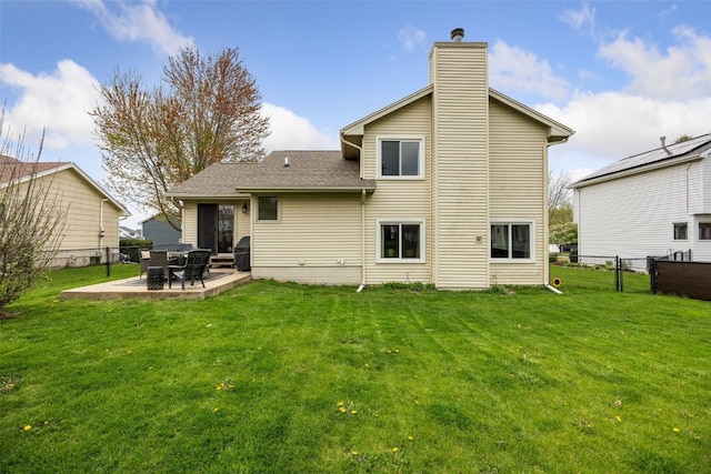 back of house with a lawn, fence, a chimney, and a patio area