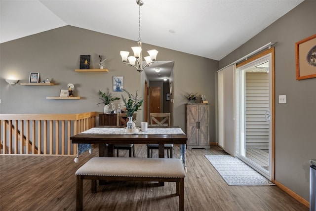 dining area featuring baseboards, a notable chandelier, wood finished floors, and lofted ceiling