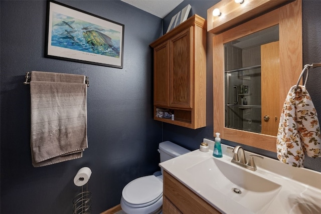 bathroom featuring vanity, toilet, and a shower stall