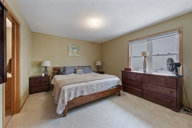 bedroom featuring light carpet and a textured ceiling