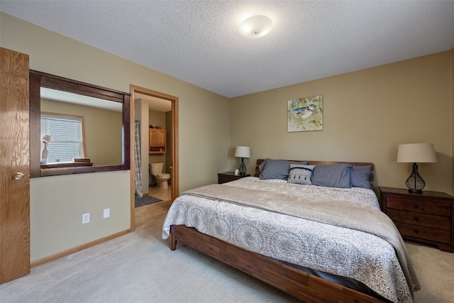 carpeted bedroom featuring a textured ceiling and connected bathroom