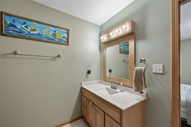 bathroom featuring a textured ceiling, tile patterned floors, baseboards, and vanity