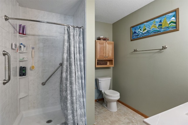 bathroom featuring tile patterned floors, a textured ceiling, a stall shower, and toilet
