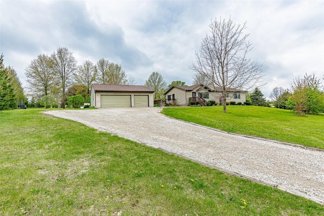 ranch-style house featuring a garage, an outdoor structure, a front lawn, and gravel driveway