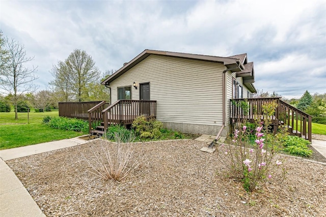 view of side of home featuring a lawn and a deck