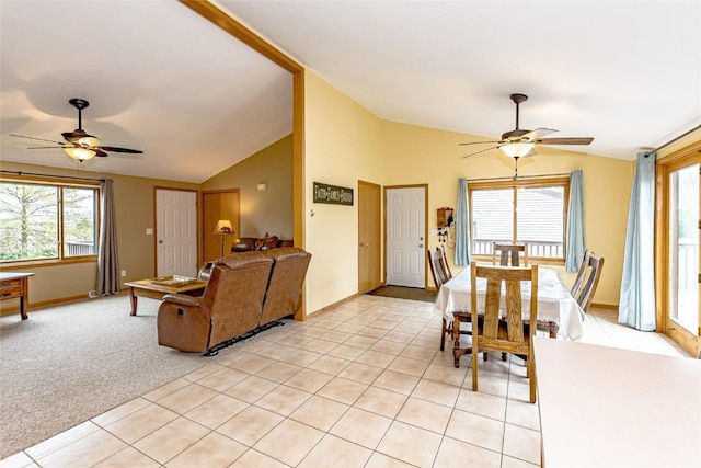 living area with ceiling fan, lofted ceiling, a wealth of natural light, and light tile patterned floors