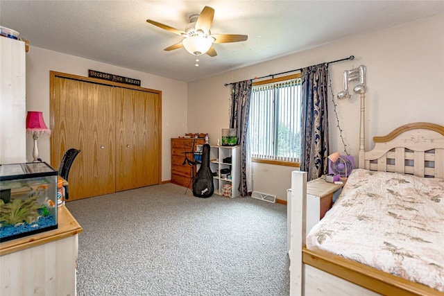 carpeted bedroom with baseboards, ceiling fan, a closet, and visible vents