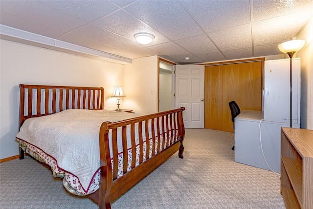 carpeted bedroom featuring a drop ceiling