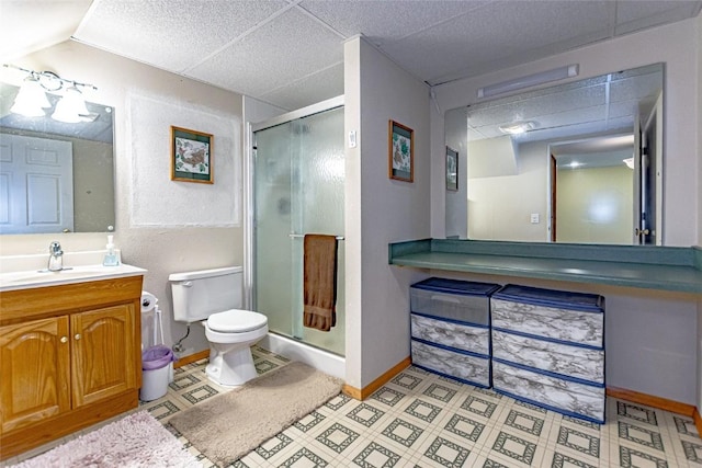 bathroom featuring vanity, a paneled ceiling, toilet, and a shower stall