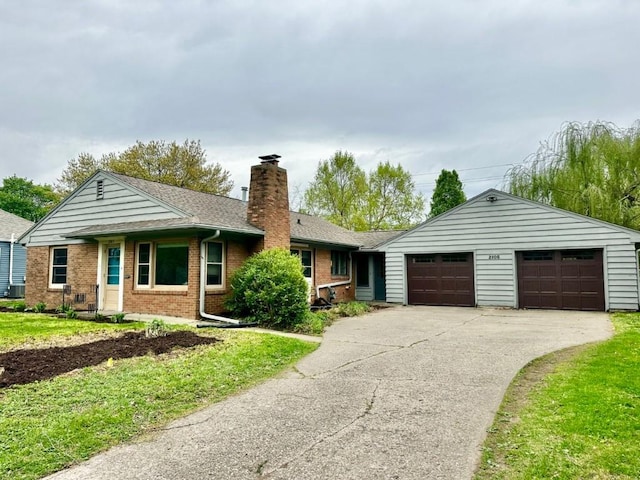 2105 Muscatine Ave, Iowa City, IA 52240 - ranch-style home featuring a garage, a chimney, brick siding, a shingled roof, and concrete driveway