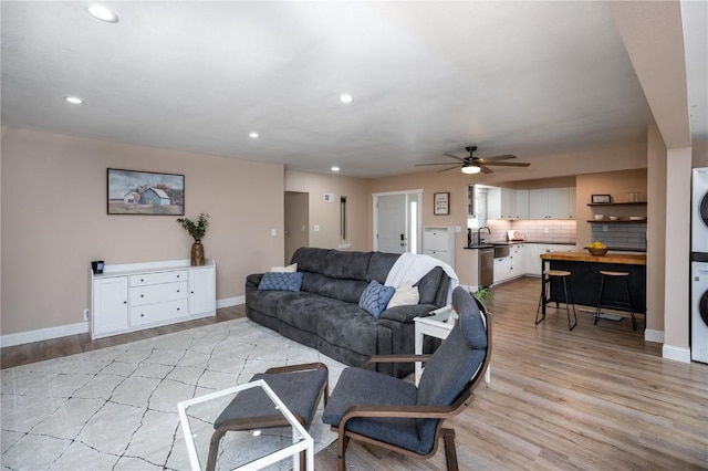 living area with stacked washing maching and dryer, ceiling fan, light wood-style floors, and recessed lighting