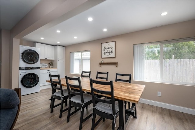 dining room featuring recessed lighting, baseboards, stacked washer / dryer, and light wood-style flooring