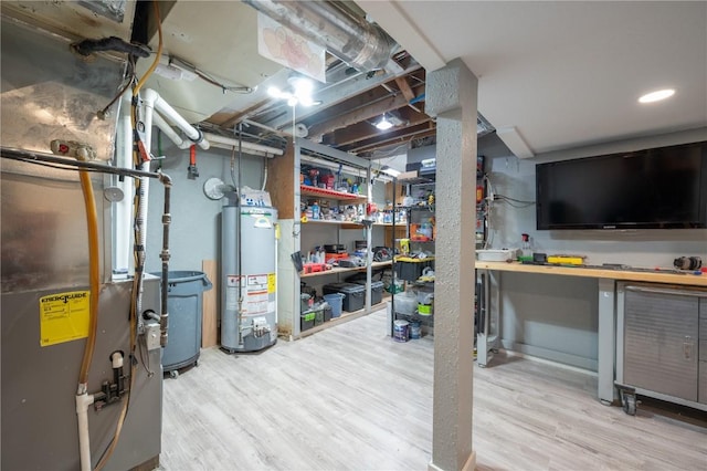 unfinished below grade area featuring heating unit, wood finished floors, and gas water heater
