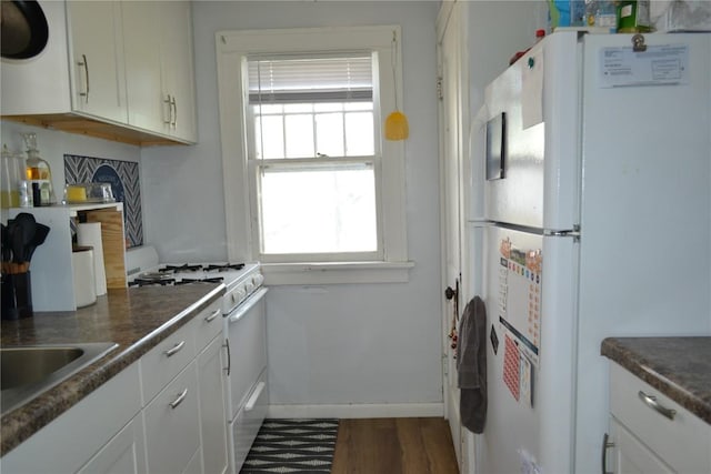 855 Center Pt NE, Cedar Rapids, IA 52402 - kitchen featuring white appliances, dark wood-type flooring, white cabinets, and dark countertops