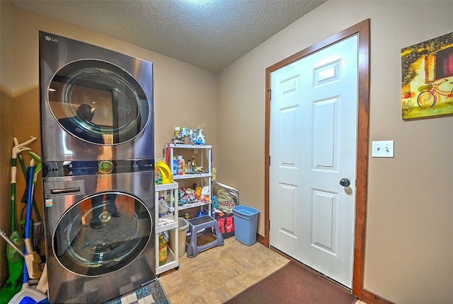 laundry area featuring stacked washer and clothes dryer, a textured ceiling, and laundry area