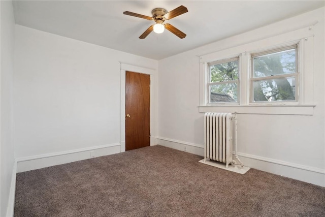 spare room with radiator, a ceiling fan, and carpet floors