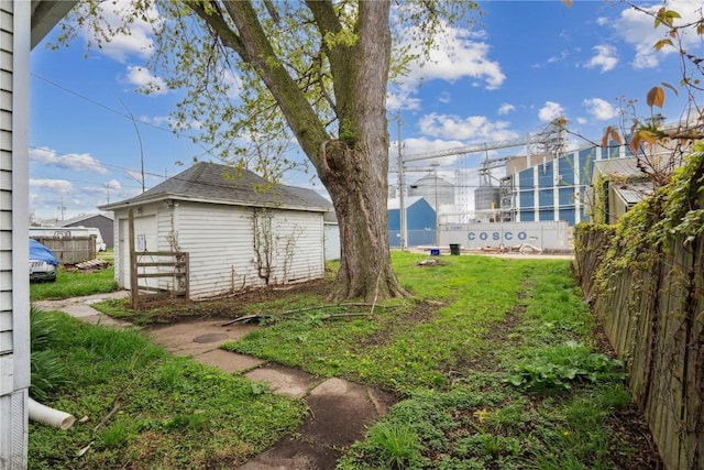view of yard featuring fence and an outbuilding