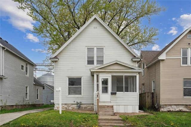 view of front facade with a sunroom, fence, and a front yard