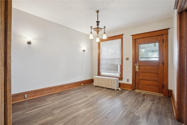foyer with radiator, baseboards, and wood finished floors