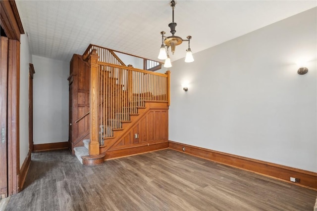 interior space featuring baseboards, a notable chandelier, and wood finished floors