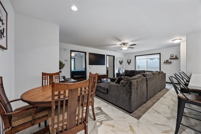 living area featuring marble finish floor and ceiling fan