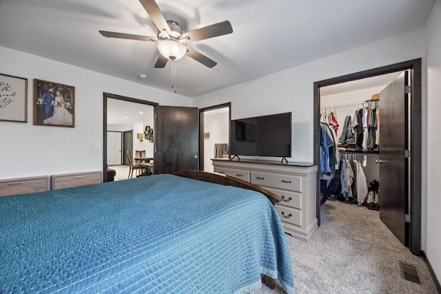 bedroom featuring light carpet, visible vents, a ceiling fan, a spacious closet, and a closet
