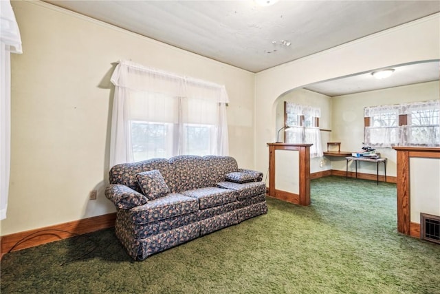 carpeted living room with arched walkways and plenty of natural light