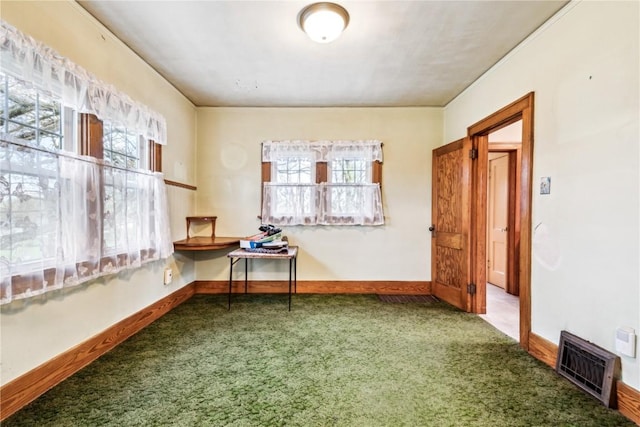 carpeted spare room featuring baseboards and visible vents