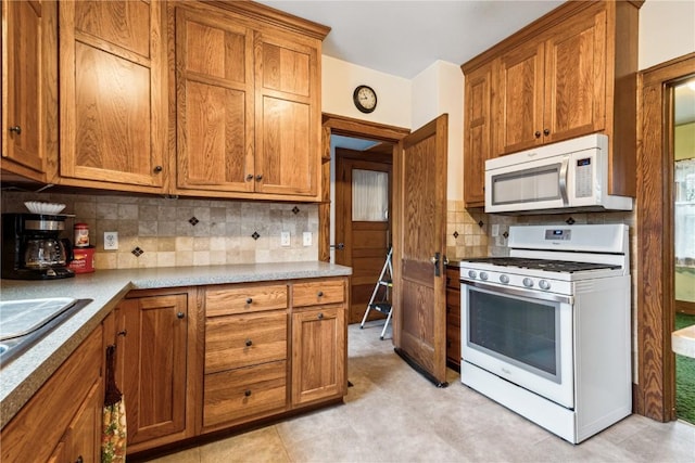 kitchen with white appliances, brown cabinets, and decorative backsplash