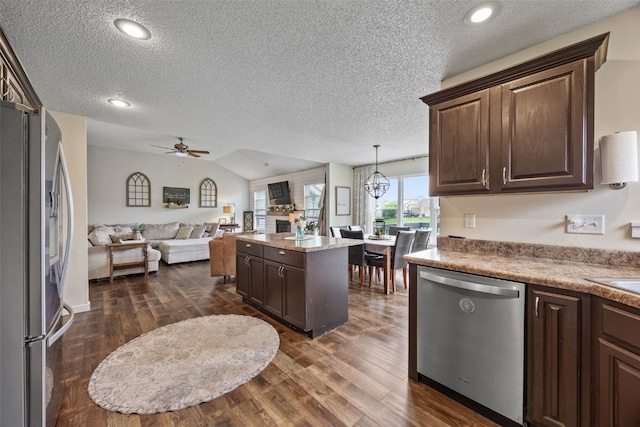 kitchen with a textured ceiling, dark wood-style flooring, dark brown cabinetry, and stainless steel appliances