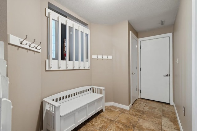 bedroom featuring a textured ceiling, baseboards, and visible vents