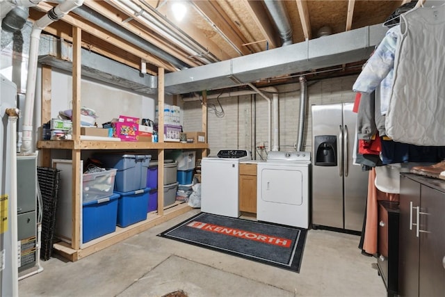 unfinished basement featuring washing machine and dryer and stainless steel fridge