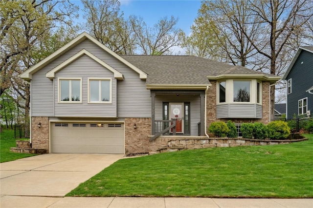 bi-level home featuring brick siding, driveway, a front lawn, and a garage