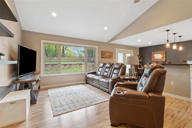 living area featuring baseboards, vaulted ceiling, and light wood-type flooring