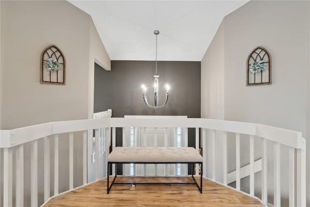 dining room with vaulted ceiling, wood finished floors, and a notable chandelier