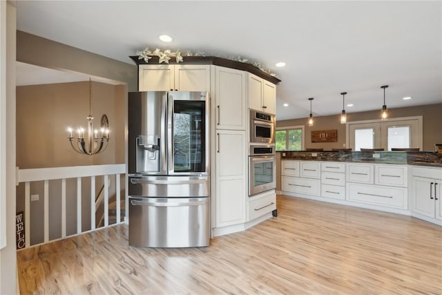 kitchen with hanging light fixtures, light wood finished floors, a chandelier, stainless steel appliances, and recessed lighting