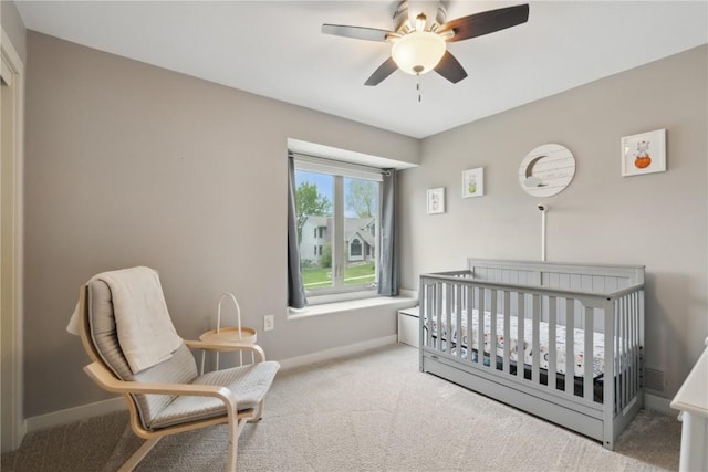 bedroom featuring carpet flooring, baseboards, and a crib