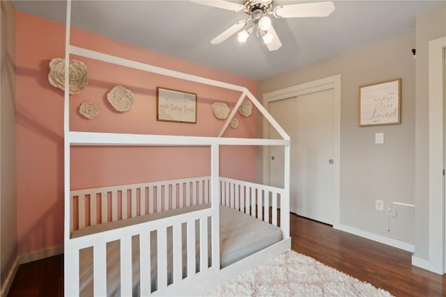 bedroom with baseboards, ceiling fan, a closet, and wood finished floors