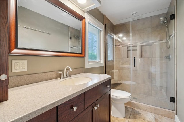 full bathroom featuring vanity, tile patterned flooring, toilet, and a shower stall