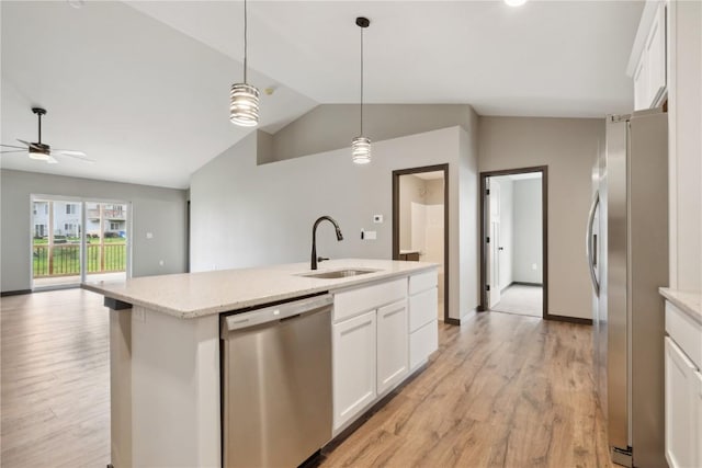 kitchen featuring white cabinets, appliances with stainless steel finishes, a sink, light wood-type flooring, and vaulted ceiling