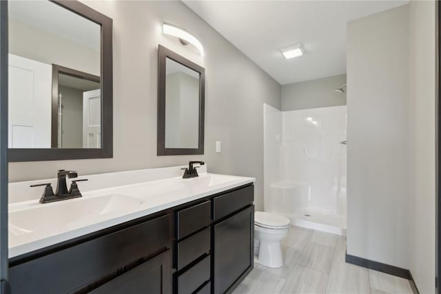 bathroom with a sink, walk in shower, toilet, and double vanity