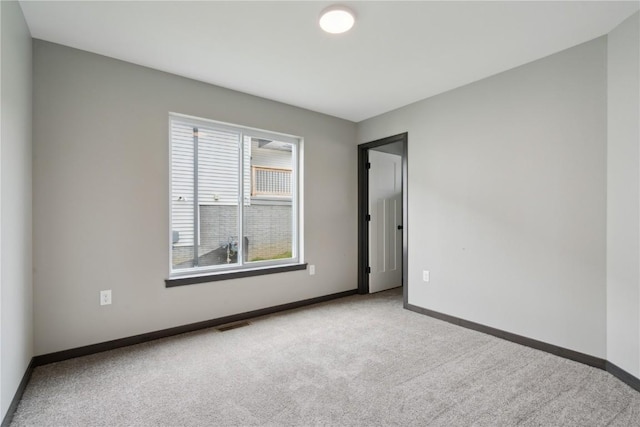 carpeted spare room with baseboards and visible vents