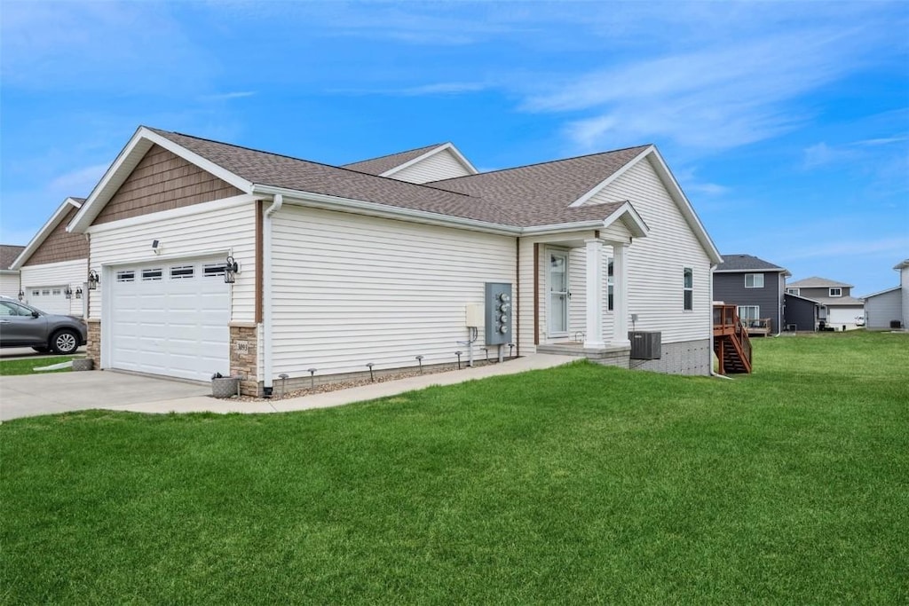 view of home's exterior featuring a lawn, stone siding, roof with shingles, an attached garage, and driveway