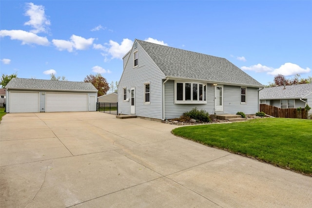 cape cod-style house featuring fence, a shingled roof, a front lawn, a garage, and an outdoor structure