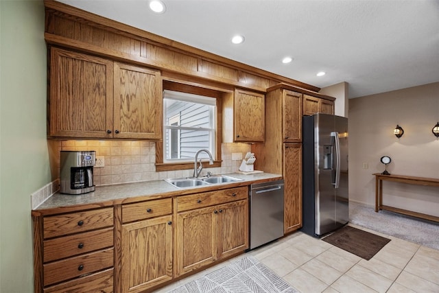 kitchen with light countertops, stainless steel appliances, a sink, and tasteful backsplash