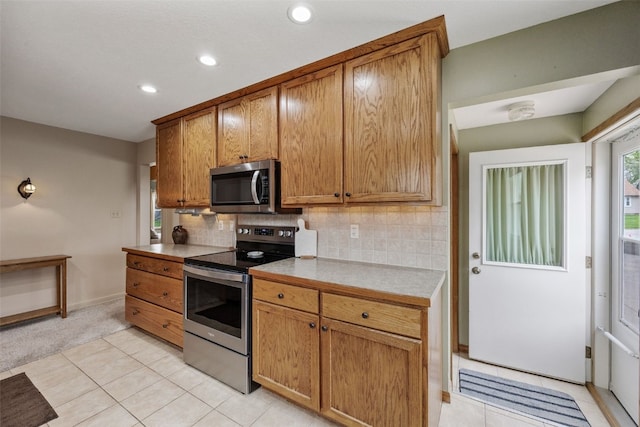 kitchen with backsplash, appliances with stainless steel finishes, light countertops, recessed lighting, and light tile patterned flooring