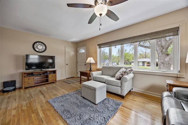 living room with baseboards, plenty of natural light, and light wood-type flooring