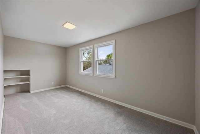 carpeted spare room with baseboards